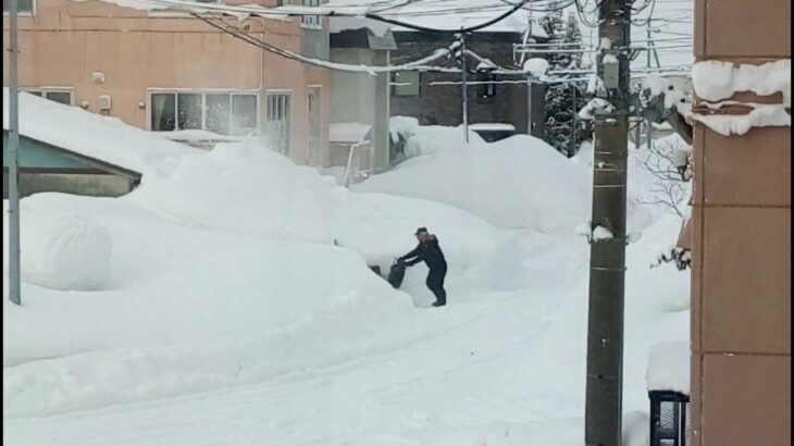 家庭用除雪機で雪を噴射排雪する豪雪地岩見沢の積雪除雪作業風景　・北海道雪景色