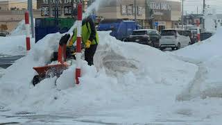 道路除雪の山を除雪機で除去