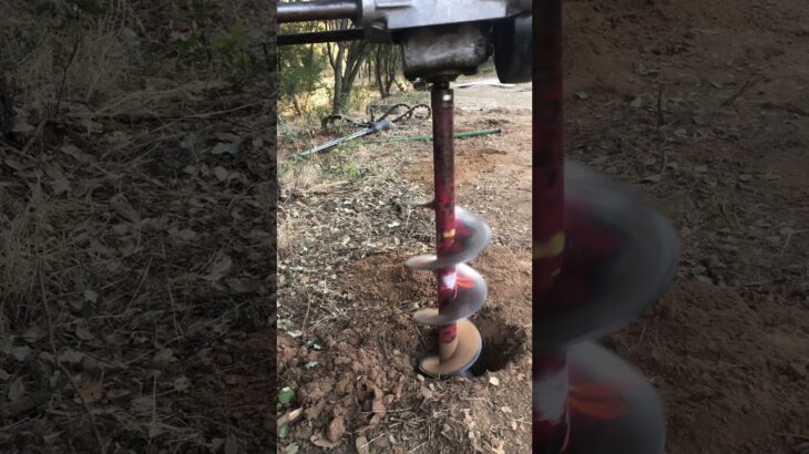 Auger digging post holes stock footage